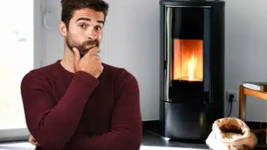 Un homme devant un poêle à pellets.
